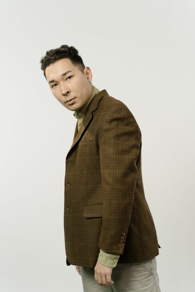 Portrait of a fashionable man in a brown suit, showcasing modern style.